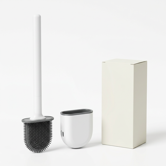 White toilet brush with dark gray flat head, rounded holder and unbranded ivory carton on white background.